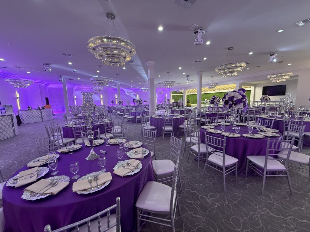 Indoor wedding venue with purple reception décor and elegant banquet seating